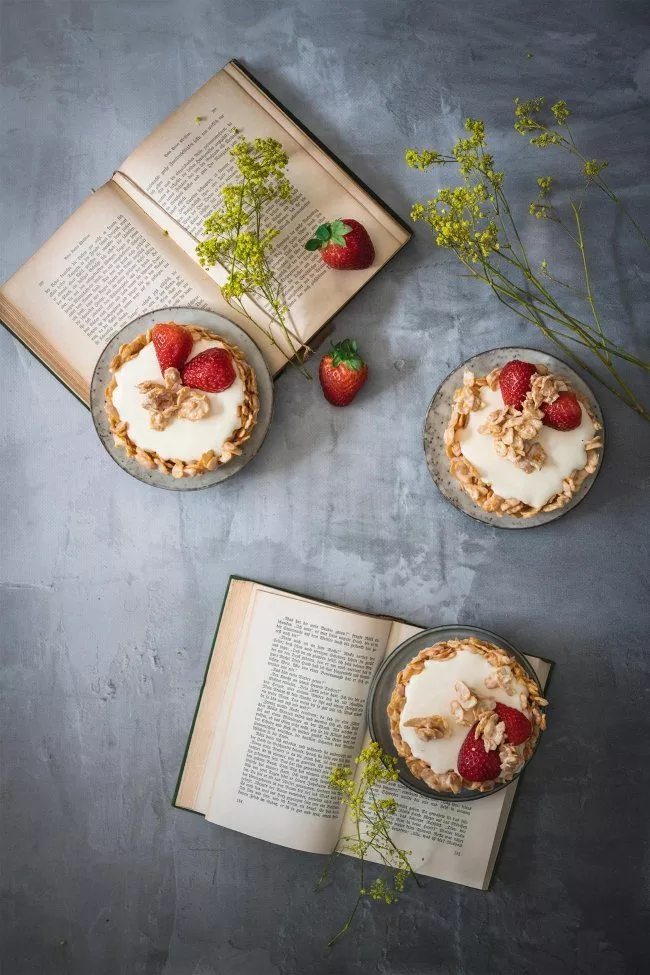 Ein riesengroßer Choco Crossie mit weißer Schokolade und einer Mascarponefüllung mit Erdbeeren? Gibt es nicht? Gibt es doch. Und zwar ganz flott gemacht und erfrischend lecker. Okay, eigentlich sollten 6 kleine Törtchen auf das Foto, aber ich finde 3 sehen genauso schick aus, oder? Leider gab es zum Zeitpunkt des Fotos nämlich nur noch 3 Törtchen. Dafür hatte ich aber reichlich Füllung übrig, die jetzt kurzerhand zum Dessert im Glas wurde. Aber was war den anderen 3 Törtchen passiert? Ich hab sie gegessen. Und zwar noch bevor ich die Füllung aufgeben konnte. Beim herausnehmen der Törtchen aus der Form hatte ich gehofft, dass mindestens ein Törtchen kaputt geht und damit automatisch zum Verzehr freigegeben ist. Nix da. Alle kamen perfekt aus der Form. Blöd. Also musste ich etwas grobmotorisch mit den anderen Zutaten rumwerkeln, so dass ich zufällig etwas auf ein kleines Törtchen fallen ließ. Wie schade. Aber umso besser, so konnte ich das Choco Crossie Törtchen direkt mal probieren. Da waren es nur noch 5. Aber hey, die anderen beiden wurden einfach schnell aufgegessen. Das musste so sein. Die waren lecker. Und man sollte auf seinen Körper hören. Und dieser (also meiner) hatte zu diesem Zeitpunkt ziemlich laut nach Choco Crossies gerufen. Dafür gibt es ja die innere Stimme. Die sagt doch einem, was der Körper braucht. Da waren es nur noch 3. Und die hab ich jetzt ganz brav in den Kühlschrank gestellt und werde sie bis morgen aufbewahren. Es sein denn, dass mein Körper oder meine Seele nochmals nach einem kleinen Törtchen schreit.