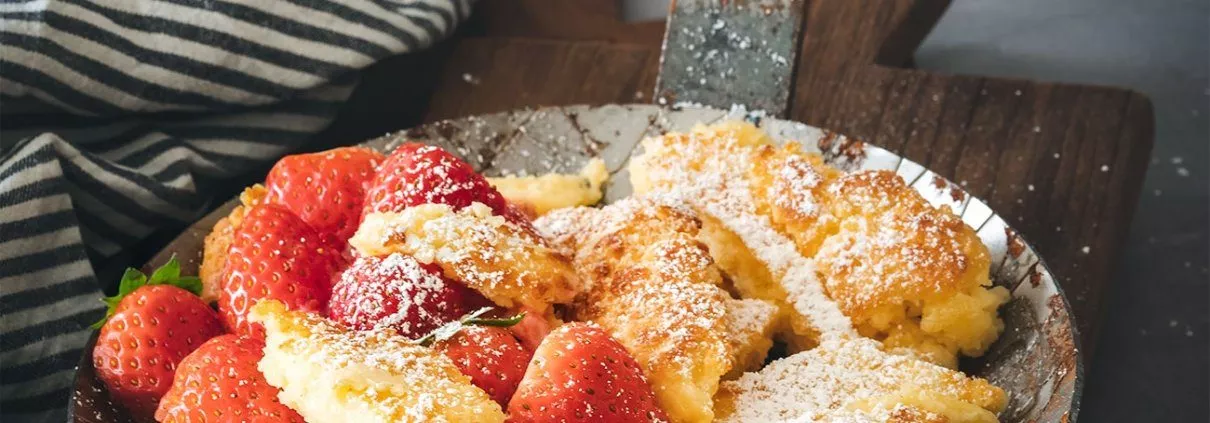 Du magst Grießpudding und Kaiserschmarren? Dann mach Dir eine Pfanne voller Grießschmarrn. Warm aus dem Ofen ein Hammer! So ein richtiger Kaiserschmarrn oder Kaiserschmarren (ich hab noch nicht herausgefunden ob mit „e“ oder ohne „e“ und nehme die vom Duden empfohlene Schreibweise), ist und bleibt einfach was richtig Tolles. Die Version mit Grieß kannte ich selber noch nicht und hab diese in einer Zeitschrift gesehen und das Rezept wanderte direkt auf meine „to do“ Liste. Meistens habe ich nämlich auch immer alle Zutaten im Haus, um die manchmal plötzlich auftretende Kaiserschmarren-Lust, zu befriedigen. Und ich war wirklich überrascht wie lecker ein Kaiserschmarren mit Grieß sein kann. Das wird jetzt öfter so gemacht. Heute mal mit frischen Erdbeeren und viel Puderzucker. Ansonsten gerne auch mal mit Fruchtsirup und Vanillesoße.