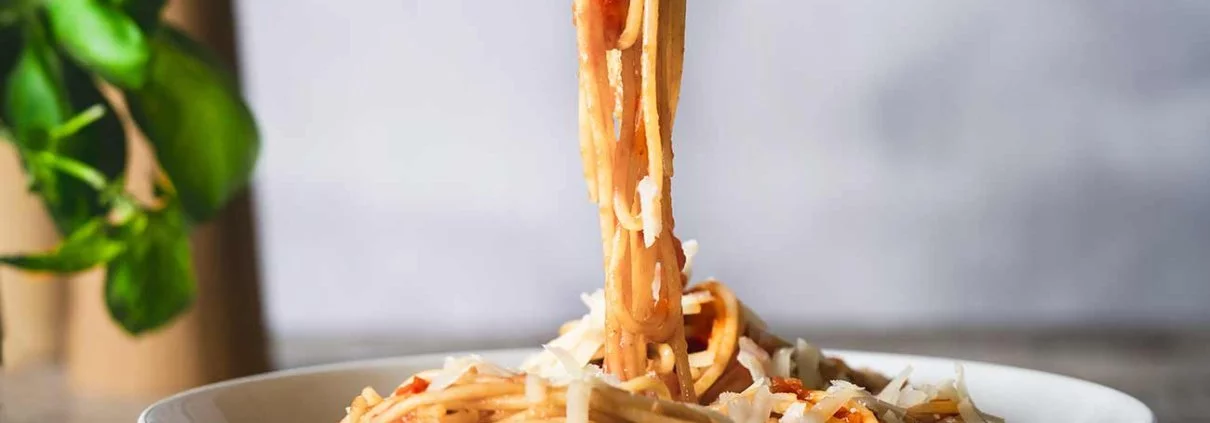 Eine gute Tomatensoße braucht nicht viele Zutaten. Sie muss nur ganz gemütlich ein Stündchen vor sich hin köcheln. In der Zeit kann man die Beine hochlegen, Pasta kochen und Parmesan reiben. Herrlich, so ein Tag!