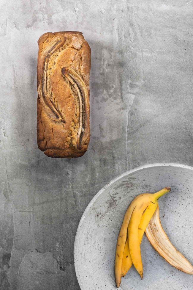 Peanut butter banana bread Erdnussbutter Bananenbrot Das Bananenbrot war eigentlich schon immer ein Erfolgsrezept, denn es schmeckt einfach super lecker. Derzeit sind überall richtig tolle Rezepte zu sehen. Bananenbrot revival. Mein Lieblingsbananenbrot? Mit Erdnussbutter drin! Und ich finde, dass ein Bananenbrot in seiner Schlichtheit einfach so wunderschön ist, dass es auch ganz ohne „Klimbim“ auf dem Foto auskommt. Habt einen tollen, sonnigen Tag. 4 reife Bananen 50 g Erdnussbutter 120 ml Speiseöl 75 ml Milch 300 g Mehl 175 g brauner Zucker 2 TL Backpulver 0,5 TL Zimt 1 Prise Salz Backofen auf 180 Grad Umluft vorheizen Kastenform (ca. 25 x 13 cm) mit Backpapier auslegen und leicht einfetten 3 Bananen mit einer Gabel zerdrücken und zusammen mit der Erdnussbutter, Öl und Milch verrühren In einer zweiten Schüssel Mehl, Zucker, Backpulver, Zimt und eine Prise Salz vermengen Bananenmischung zur Mehlmischung geben und verrühren Teig in die Kastenform geben Restliche Banane längs halbieren und auf den Teig legen Im Ofen 45-50 Minuten goldbraun backen