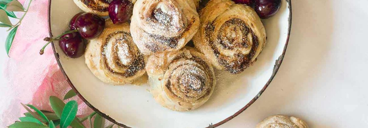Almond Cherry rolls Mandel-Kirsch-Schnecken Jetzt wird es mal wieder flott, denn fertiger Blätterteig ist im Spiel. Mit einer Füllung aus Mandeln und Kirschmarmelade schmecken die kleinen Schneckchen einfach unwiderstehlich. 12 Stück 2 Rollen frischer Blätterteig 50 g Butter, Zimmertemperatur 50 g Zucker 50 g gemahlene Mandeln 1 TL Mehl 1 Eigelb 3 TL Kirschmarmelade Puderzucker Backofen auf 180 Grad Ober-Unterhitze vorheizen Eine Muffinform leicht einfetten Blätterteig entrollen Butter, Zucker, Mandeln, Mehl und Eigelb vermengen Kirschmarmelade auf den Teig streichen Buttermasse darübergeben und verteilen Teig in je 3 Streifen schneiden und je Streifen von der kurzen Seite her aufrollen, in der Mitte einmal teilen und in die Muffinform setzen Im Ofen ca. 20 Minuten goldbraun backen Vor dem Servieren mit Puderzucker bestäuben