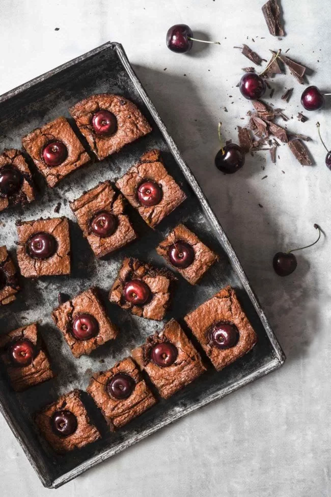 Cherry-Chocolate Cake Kirsch-Schokoladen Kuchen Es gibt Kuchen und es gibt „DIE“ Kuchen. DIE Kuchen sind voller Schokolade und innen noch ganz saftig. Ich kann dann kaum erwarten diese in Stücke zu schneiden und Menschen (also die, die ich kenne) in den Mund zu stecken. Denn ich weiß ganz genau was passiert: noch während sie kauen, verdrehen sie leicht die Augen und ein „WOW“ ertönt. Ich mag das. Natürlich kannst du auch Kirschen ohne Kerne nehmen, aber für das Foto sahen die Kirschen mit Stil einfach schöner aus. 1 Form ca. 20 x 20 cm 100 g Butter 400 g Vollmilchschokolade 4 Eier 150 g Zucker 1 Prise Salz 200 g gemahlene Mandeln 2 EL Kirschwasser 6 EL Mehl ca. 20 Kirschen Butter und Schokolade über einem Wasserbad langsam schmelzen lassen Eier mit Zucker und Salz schaumig aufschlagen Schokoladenmasse, Mandeln, Kirschwasser und Mehl zugeben und verrühren Backofen auf 200 Grad Ober-Unterhitze vorheizen und eien Springform mit Backpapier auslegen Teig in die Form geben und glatt streichen Die Kirschen in den Teig drücken Teig im Ofen 25 -30 Minuten backen (falls der Kuchen zu dunkel wird, mit Alufolie abdecken), herausnehmen und vollständig abkühlen lassen