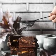 Brownies with melted caramel core Brownies mit flüssigem Karamellkern Kalorienverweigerer, Karamellhasser und Schokoladenzurückweiser bitte wegschauen, denn hier kommt eine Leckerei auf dem Tisch die es in sich hat. Jeder Bissen dieser Brownies schmilzt köstlich in deinem Mund. Die Ränder sind knackig, die Mitte ist „chewy“ und sie haben die perfekte Süße. 1 Springform ca. 20 x 30 cm 250 g Zartbitterschokolade gehackt 250 g Butter 200 g Mehl 1 Pck. Backpulver 100 g Kakaopulver 200 g brauner Zucker 100 g Zucker 1 Prise Salz 2 Päckchen Vanillezucker 8 Eier 200 g Crème fraîche 2 Tafeln Schokolade gefüllt mit Karamell (á 200 g) Puderzucker zum bestäuben Backofen auf 150 Grad Umluft vorheizen Springform mit Backpapier auslegen Schokolade mit der Butter langsam in einem Topf zum schmelzen bringen Mehl, Backpulver, Kakao, braunen Zucker, Zucker, Vanillezucker und Salz vermengen Eier schaumig schlagen, geschmolzene Schokolade unterrühren Mehlmischung zugeben und unterrühren Crème fraîche unterrühren Die Hälfte des Teigs in die Springform geben, Schokolade darauf verteilen, restlichen Teig darüber geben und im Ofen 45 Minuten backen Abkühlen lassen, aus der Form nehmen und auf ein Kuchengitter geben In Stücke schneiden und vor dem Servieren mit Puderzucker bestäuben