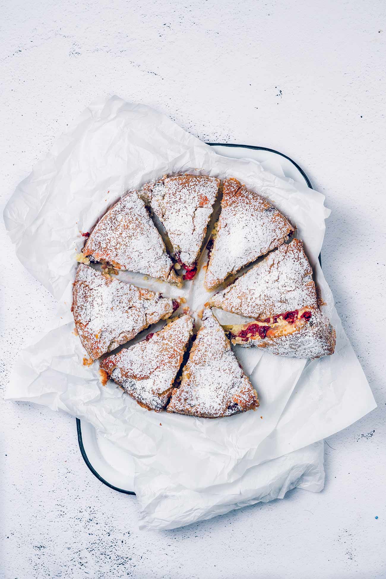 Hmmm… ein feuchter, leichter und luftiger Kirschkuchen mit einer leichten Zuckerkruste. Er ist einfach perfekt. Dies ist der Kuchen, den man auch mal in der Woche backen kann. Er ist so einfach zu machen, dass man ihn nach der Arbeit zubereiten und noch warm genießen kann, einfach so oder mit einer Kugel Vanilleeis darüber. 