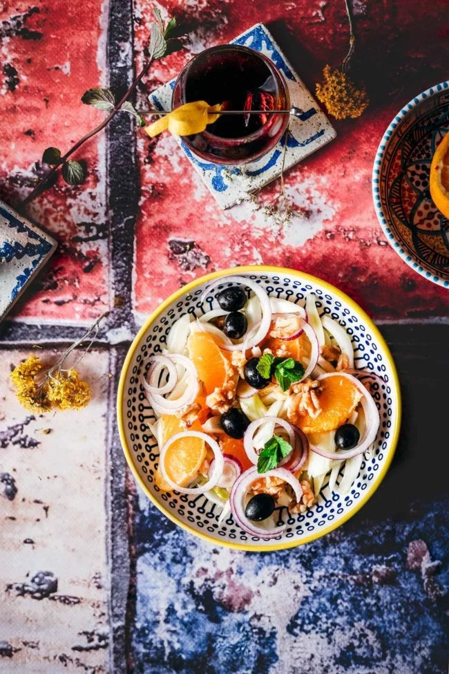 Insalata di arance siciliana 4 Portionen 2 Fenchelknollen 2 Orangen 1 rote Zwiebel, geschält und in Scheiben geschnitten 8 Walnüsse, grob gehackt 1 Handvoll schwarze Oliven, entsteint 1 cm frischen Ingwer, fein gehackt 2 Stiele frische Minze Salz Olivenöl extra vergine Rotweinessig Äußere Blätter und Stängel vom Fenchel entfernen und Fenchel in feine Spalten schneiden oder fein hobeln Den Saft einer Orange auspressen und auffangen, zweite Orange filetieren. Fenchel, Orangenspalten zusammen mit Ingwer und Walnüssen vermengen. Oliven und Zwiebeln untermengen. Mit Salz, Olivenöl, Orangensaft und etwas Essig vermengen und mit frischer Minze servieren