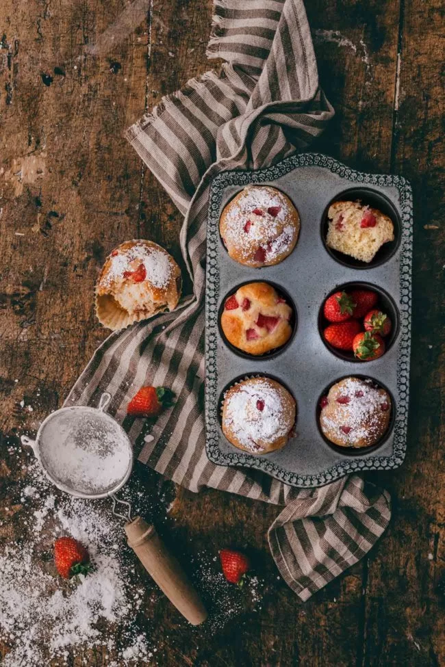 Mandel-Erdbeer Muffins Almond and Strawberry Muffins Mandel-Erdbeer-Muffins! Süß, buttrig, extra weich, mit frischen Erdbeeren beladen und gesüßt mit Honig. Sie sind super einfach zu machen! Versuche sie, noch leicht warm zu essen oder direkt aus dem Ofen. Ich verspreche dir, du wirst nicht enttäuscht sein. 2 Eier 70 g Honig 1 Prise Salz 100 g Marzipanrohmasse, geraspelt 200 ml Mandel-Drink 1 Bio-Zitrone 250 g Mehl 2 TL Backpulver 200 g Erdbeeren, gewürfelt Puderzucker Backofen auf 180 Grad Ober-Unterhitze vorheizen und ein Muffin-Backblech mit Papierförmchen auslegen Eier, Honig und Salz schaumig rühren Marzipan und Mandel-Drink unterrühren Schale der Zitrone abreiben und mit 1 TL Zitronensaft unterrühren Mehl und Backpulver vermengen und unterrühren Edbeerwürfel unterheben Teig in die Förmchen füllen und 20-25 Minuten backen Vor dem Servieren mit Puderzucker bestäuben TIPP: Erdbeerwürfel einen Tag vorher in etwas Sekt einlegen