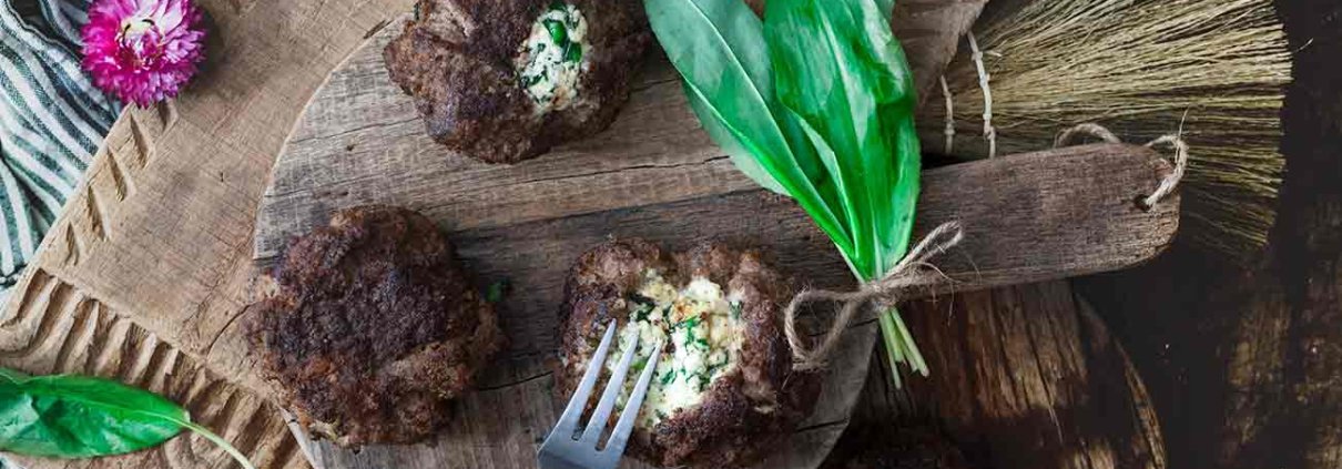 Bärlauch-Käse Frikadellen Wild garlic cheese meatballs Puh, da war ich aber froh, dass ich aus dem Garten noch etwas Bärlauch retten konnte, bevor dieser durch eine dichte Schneedecke wieder vergraben war. Ich habe das Glück, dass der Bärlauch im Garten richtig gut gedeiht und wir uns auf viele tolle Bärlauchrezepte freuen können. 6 Stück 40 g Bärlauch, fein gehackt 150 g fester Frischkäse oder Weißkäse Salz Pfeffer 1 rote Zwiebel, fein gehackt 1 EL Butter 500 g Hackfleisch, gemischt 30 g Paniermehl 2 EL Butterschmalz 1 Ei 2 TL Senf Gehackten Bärlauch zusammen mit dem Käse mit einer Gabel zerdrücken und mit Salz und Pfeffer würzen Käsemasse zu 6 kleinen Kugeln formen Zwiebelwürfel in der Butter glasig andünsten, abkühlen lassen Zwiebelwürfel, Hackfleisch, Paniermehl, Ei und Senf verkneten und mit Salz und Pfeffer würzen Hackfleisch zu 6 Kugeln formen, etwas flach drücken und in die Mitte die Käsekugel setzen Hackfleisch darüber schlagen, sodass der Käse gut umhüllt ist Butterschmalz in einer großen Pfanne erhitzen und die Frikadellen von jeder Seite 5 Minuten braten, dann warm stellen TIPP: Ich mache aus den Bratensatz immer noch eine Soße, indem ich den Bratensatz mit 100 ml Weißwein ablösche. Ich rühre dann 1 TL Speisestärke mit Wasser an und rühre diese zusammen mit 200 ml Rinderbrühe in die Pfanne und lasse alles unter Rühren aufkochen und 5 Minuten köcheln. Anstelle von festen Frischkäse (Formaggini oder Ziegenfrischkäse) kannst du auch gut einen Feta-Käse nehmen.