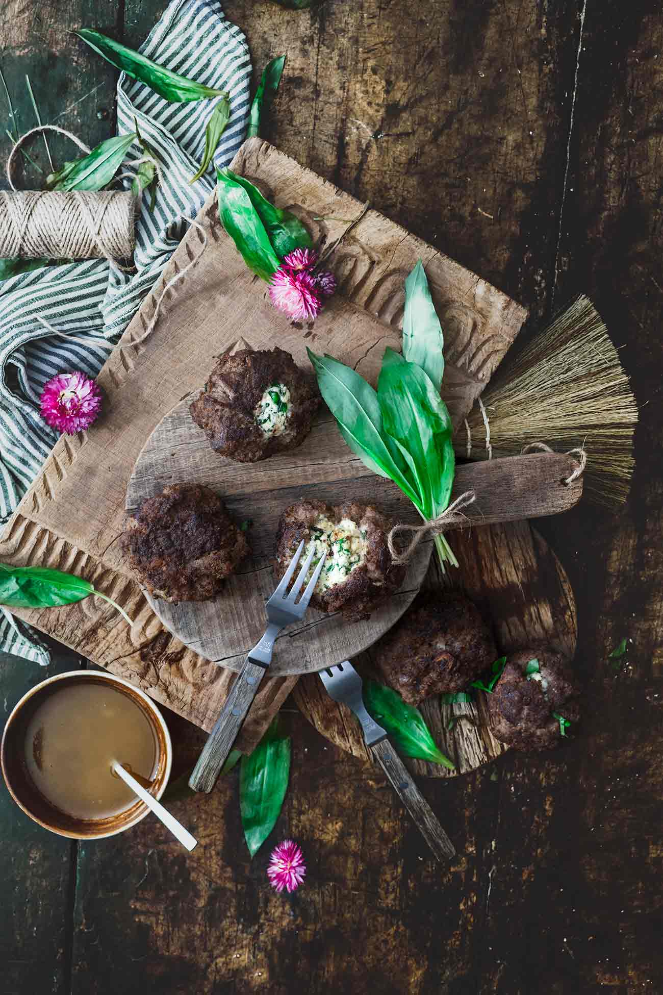 Bärlauch-Käse Frikadellen Wild garlic cheese meatballs Puh, da war ich aber froh, dass ich aus dem Garten noch etwas Bärlauch retten konnte, bevor dieser durch eine dichte Schneedecke wieder vergraben war. Ich habe das Glück, dass der Bärlauch im Garten richtig gut gedeiht und wir uns auf viele tolle Bärlauchrezepte freuen können.    6 Stück  40 g Bärlauch, fein gehackt 150 g fester Frischkäse oder Weißkäse Salz Pfeffer 1 rote Zwiebel, fein gehackt 1 EL Butter 500 g Hackfleisch, gemischt 30 g Paniermehl 2 EL Butterschmalz 1 Ei 2 TL Senf  Gehackten Bärlauch zusammen mit dem Käse mit einer Gabel zerdrücken und mit Salz und Pfeffer würzen Käsemasse zu 6 kleinen Kugeln formen Zwiebelwürfel in der Butter glasig andünsten, abkühlen lassen Zwiebelwürfel, Hackfleisch, Paniermehl, Ei und Senf verkneten und mit Salz und Pfeffer würzen Hackfleisch zu 6 Kugeln formen, etwas flach drücken und in die Mitte die Käsekugel setzen Hackfleisch darüber schlagen, sodass der Käse gut umhüllt ist Butterschmalz in einer großen Pfanne erhitzen und die Frikadellen von jeder Seite 5 Minuten braten, dann warm stellen   TIPP: Ich mache aus den Bratensatz immer noch eine Soße, indem ich den Bratensatz mit 100 ml Weißwein ablösche. Ich rühre dann 1 TL Speisestärke mit Wasser an und rühre diese zusammen mit 200 ml Rinderbrühe in die Pfanne und lasse alles unter Rühren aufkochen und 5 Minuten köcheln.  Anstelle von festen Frischkäse (Formaggini oder Ziegenfrischkäse) kannst du auch gut einen Feta-Käse nehmen. 