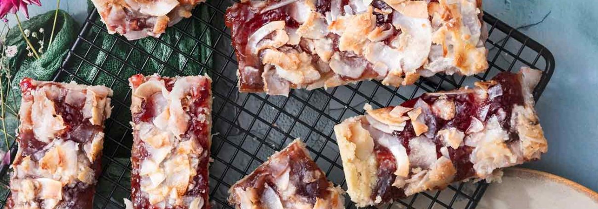 Süßer Mürbeteig bestrichen mit klebriger Marmelade und knackiger Eiweiß-Kokosmasse. Ganz mein Geschmack. Das sind genau die Riegel, die man am liebsten für sich ganz alleine behalten will, aber da ich direkt ein ganzes Blech gebacken habe, ist genug für alle da. Greift zu.