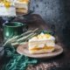Buttermilch Kokos-Mango Torte Buttermilk Coconut Mango cake Wenn man, wie ich, den Sommer nicht erwarten kann…dann backt man sich eben eine Sahnetorte mit Mango, Maracuja und Kokos. Und Buttermilch. Was das Beste an diesem Kuchen ist? Er schmeckt fantastisch, gelingt ziemlich leicht und ist auch noch hübsch. Ich habe das Gefühl, dass so viele hübsche Kuchen trocken und geschmacklos sind, aber dieser Kuchen ist alles andere als ... er ist feucht, luftig und irgendwie sonnig. 3 Eier 220 g Zucker 3 Pck. Vanillezucker 1 Prise Salz 125 g Mehl ½ TL Backpulver 300 ml Buttermilch 1 Pck. Tortenguss klar 350 ml Maracuja-Nektar 6 Blatt Gelatine 1000 ml Sahne 3 Pck. Sahnesteif 5 TL Kokosraspeln 3 Dosen Mango (je ca. 425 g) Backofen auf Umluft 150 Grad vorheizen und eine Springform 26 cm mit Backpapier auslegen Eier trennen und das Eiweiß mit 125 g Zucker, 1 Pck. Vanillezucker und Salz steif schlagen Eigelbe einzeln unterrühren Mehl und Backpulver auf die Eiermasse sieben und unterheben 50 ml Buttermilch unterheben Teig in die Form geben und 15-20 Minuten goldbraun backen Aus der Form lösen und auskühlen und waagerecht halbieren Um den unteren Boden einen Tortenring legen Den Inhalt einer Dose Mango würfeln Tortenguss, 20 g Zucker, 250 ml Maracuja-Nektar und die Mangowürfel aufkochen Guss auf den unteren Teigboden verteilen, dabei einen kleinen Rand frei lassen Gelatine einweichen Inhalt einer Dose Mango würfeln und zusammen mit dem restlichen Nektar aufkochen lassen Vom Herd nehmen, Gelatine ausdrücken und unterrühren Restliche Buttermilch und restlichen Zucker unterrühren 2 TL Kokosraspeln unterrühren 400 ml Sahne steif schlagen und unterheben Creme auf den Tortenboden geben und oberen Boden aufsetzen, leicht andrücken und mindestens 3 Stunden kalt stellen Restliche Sahne mit Sahnesteif und restlichen Vanillezucker steif schlagen Torte aus dem Ring lösen und mit der Sahne einstreichen Restliche Sahne in einen Spritzbeutel mit Sterntülle füllen und kleine Tuffs auf die Torte spritzen Restliche Mango pürieren und Mangopüree auf die Torte geben und die restlichen Kokosraspeln darüberstreuen
