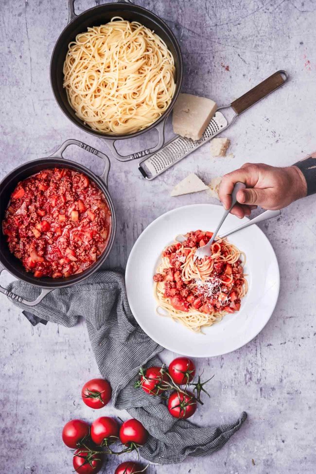 Wenn wir es genau nehmen, dann heißt die beliebte Bolognese eigentlich Ragú alla bolognese, aber so genau nehmen wir es dann doch nicht. Nur bei den Zutaten und bei der Kochzeit nehme ich es bei der Bolognese ganz genau. Klar, kann ich auch die „ruck zuck“ Variante, aber wenn die Soße langsam vor sich hinköcheln darf, mag ich sie besonders gern. Und meine Geheimzutat kommt in beiden Varianten rein: Kaffee! Ok, Kaffee ist für viele von Euch sicherlich keine Geheimzutat mehr, denn es hat sich ziemlich schnell rumgesprochen, dass etwas Kaffee (in meinem Fall ein guter Schuss Jacobs Espresso aus der Expertenröstung) mehr geschmackliche Tiefe bringt, ohne den Kaffee zu sehr in den Vordergrund treten zu lassen, aber für einige sicherlich noch ein guter Tipp. Probiert es mal aus.