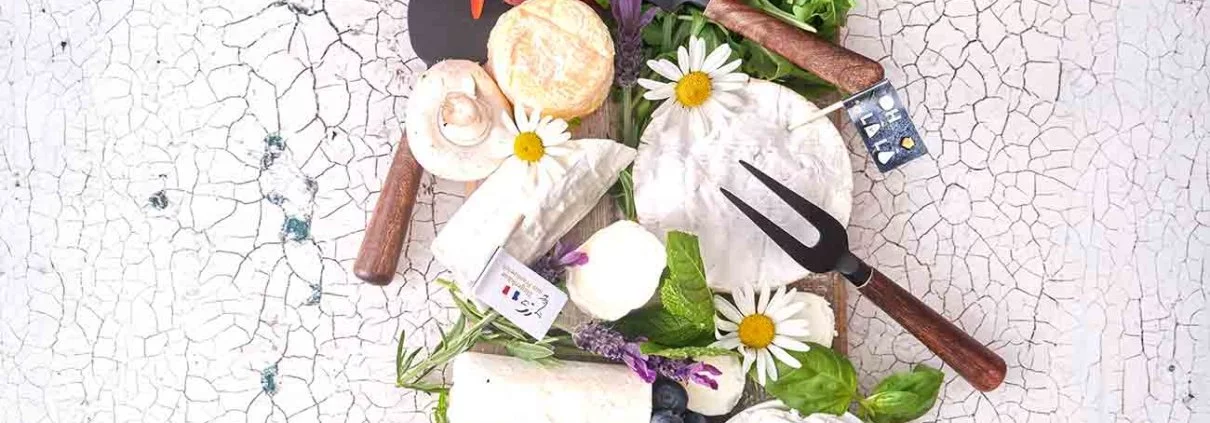 Bei mir landen sie alle auf dem Tisch: Jede Art von Ziegenkäse. Als Käse-Fan ist es doch ganz klar, dass ich fast alle Käsesorten liebe. Besonders Ziegenkäse hat es mir angetan, da er so vielfältig einsetzbar ist. Aber aus Frankreich muss er sein. Warum? Der schmeckt mir einfach am besten. Ich kann mich noch ganz genau daran erinnern, als ich das erste Mal den Südosten Frankreichs (Rhône-Alpes) bereist habe und eines Abends in einem Bauernhof-Restaurant zum Essen einkehrte. Ich bestelle eine Käseplatte, frisches Brot und ein Glas Wein. Bis dato wusste ich nicht einmal das Frankreich so ein bekanntes Ziegenkäse-Gebiet hat. Man klärte mich schnell auf, denn gerade das milde Klima und die Berglandschaft der Pyrenäen gebe dem Heu den besonderen Charakter und somit der Ziegenmilch den besonderen Geschmack. Und das schmeckt man auch. Ganz im „Frankreich-Fieber“ habe ich meine Käseplatte der französischen Flagge angeglichen. Der Selles-Sur-Cher AOP mit seiner gräulichen Färbung der Rinde (die durch das Bestäuben mit Pflanzenkohle entsteht) durfte farblich noch mit in den blauen Teil. Die anderen Käsesorten erstrahlen im hellen weiß, so dass sie das Mittelstück (und damit das Herzstück) der Käseplatte ausmachen.