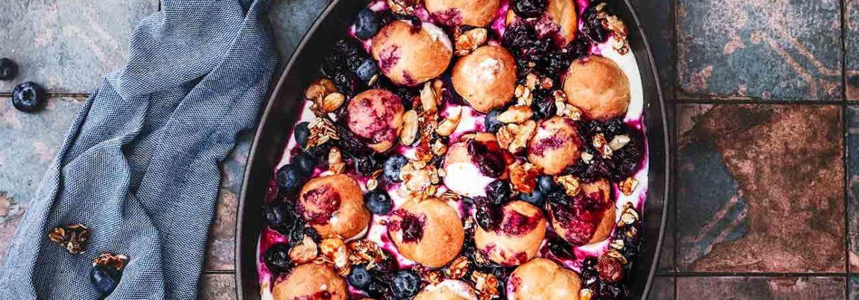 Zeit für ein Dessert! Ein „ratzfatz“-Dessert, dass einfach alle mögen werden. Sahnige Windbeutel auf Schmandsahne mit Heidelbeerkompott und karamellisierten Nuss-Topping. Klingt schon ziemlich lecker, oder?