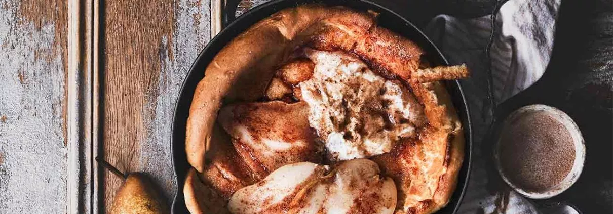 Ein Dutch Baby passt zum Frühstück genauso gut, wie auch zum Mittagessen. Eigentlich geht er immer. Dieser Ofenpfannkuchen hat noch ein Geheimnis, denn unter ihn befinden sich noch karamellisierte Birnenscheiben mit brauner Butter. Getoppt wird das Ganze dann mit Sahne und Zimtbutter. Ich habe schon viele Dutch Babys gemacht, aber dieser ist mir der Allerliebste. Das ganze Geheimnis dieses Ofen-Pfannkuchens ist, dass die Pfanne vorher schon im Ofen erhitzt werden muss, damit der Pfannkuchenteig so schön aufpufft. Warum das so ist, kann ich nicht erklären, aber was du wirklich wissen musst, ist, dass es einfach magisch ist.