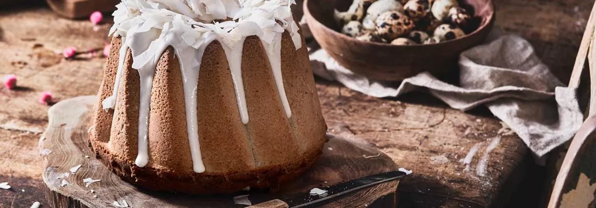 Ein bisschen „Aloha“ Feeling zwischen all den Osterhasen-Content. Bananen, Rum und Kokosnuss. Ich liebe diese Kombination einfach. Und ich erwische mich jedes Mal dabei, wenn ich die Glasur aus Puderzucker und Rum anrühre, dass ich meinen Finger immer ganz tief in die Glasur tunke, um ihn mir dann genüsslich in den Mund zu stecken. Mit der anderen Hand versuche ich mir dann noch ein paar Kokosflocken in den Mund zu werfen, so losgelöst, als wäre ich ein Basketball-Profi, der einfach jeden Korb trifft. Ich treffe natürlich nicht. Danach sieht mein Bart und T-Shirt aus, als hätte ich bei der Produktion von Erwachsenenfilmen zu nahe am Set gestanden und bei jeder Bewegung rieseln die Kokosflocken in alle Richtungen. Dann lieber ein Stück saftigen Kuchen.