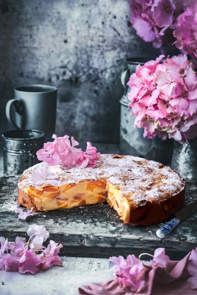 Ein Kuchen gefüllt mit frischen Pfirsichen. Süß, buttrig und so cremig, das ist der beste Pfirsich-Kuchen. Der Kuchen besteht nur aus ganz wenigen Zutaten und einer leichten Zuckerkruste. Auch wenn der Kuchen nicht wirklich von meiner Oma stammt (hört sich aber immer super an)…vertraut mir, er ist köstlich.
