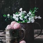 Sommer Kokos-Himbeerkugeln aus weißer Schokolade White chocolate summer coconut and raspberry balls Wenn ich mir diese kleinen Sommerkugeln machen, habe ich Bilder von weißen großen Hüten, weißen leichten Sommerkleidern, blauem Meer, weißen Stränden und lächelnden Gesichtern im Kopf. Wenn ich mich dann so umsehe, schmecken die schnell gemachten Kokoskugeln mit Mandelkern auch ohne Hut, mit Jogginganzug, umgeben von grünen, saftigen Wiesen auch sehr gut. Und lächeln kann ich auch.