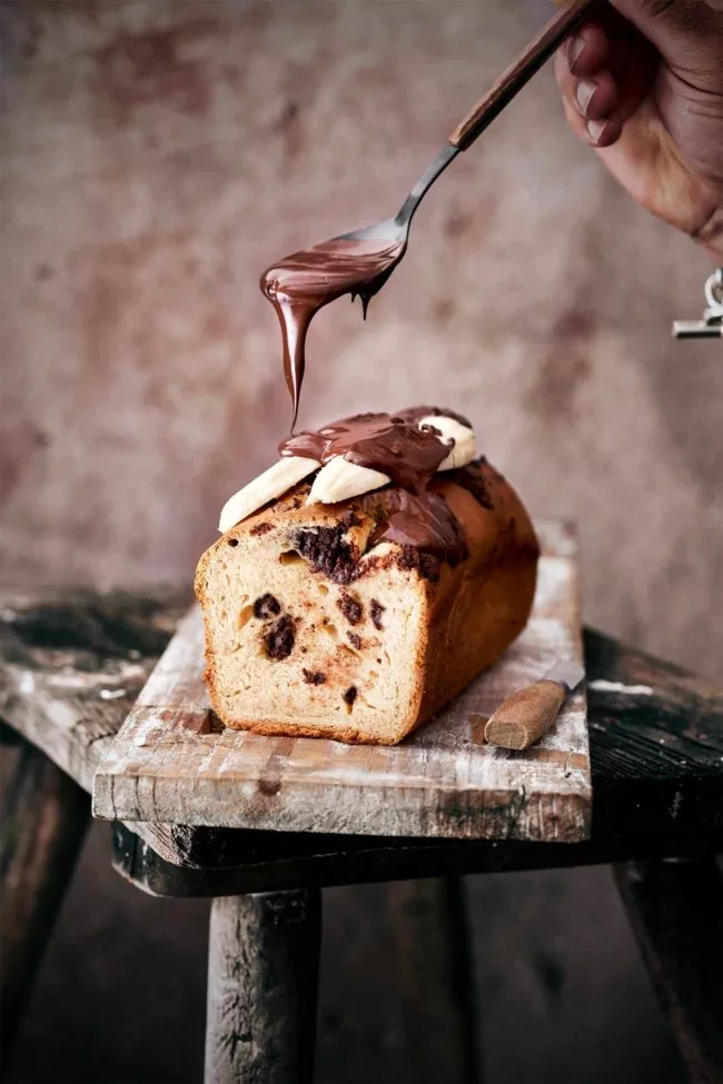 Als Kind gab es in der Eisdiele für mich entweder ein Banana-Split Eis oder den Pinocchio Becher. Ich konnte mich nie so richtig entscheiden, ob ich nun die gespaltene Banane oder das Eis mit Waffelhut und Nase besser fand. Am Ende gewann oft das Banana-Split, weil es bei uns, neben der Sprühsahne (die ich heute echt widerlich finde) auch immer ein paar Amarena-Kirschen auf der Banane landeten. Die waren einfach überzeugender als eine Nase aus einem Waffelröllchen. Heute gibt es eine Hommage an das Banana-Split Eis als Kuchen. Mit viel Schokolade und frischen Bananen, die mit noch mehr Schokolade überzogen werden. Ich serviere dazu noch etwas Sahne und…ihr ahnt es schon… ein paar Amarena-Kirschen. Da kann Pinocchio einpacken.