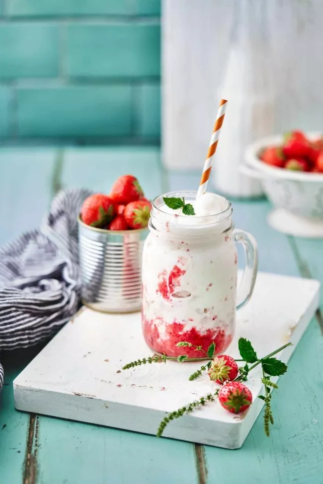 Buttermilch-Erdbeere Frappé Buttermilk Strawberry Frappé Gegen die (fast zu) heißen Tage kann man etwas tun. Viel trinken (Wasser), nackt ausziehen (nur im Homeoffice zu empfehlen) und sich ab und zu einen Frappé gönnen. Besonders wenn er so cremig wie dieser ist. Gönn Dir! 4 Portionen 1 Dose gezuckerte Kondensmilch (ca. 400 ml) 600 ml Buttermilch 1 TL Vanilleextrakt 400 g Erdbeeren (Frisch oder TK) Crushed Ice Kondensmilch, Buttermilch und Vanilleextrakt verrühren und 3 Stunden einfrieren. (am einfachsten ist es mehrere kleine Schüsseln einzufrieren) Erdbeeren pürieren. Gefrorene Milch in einem Hochleistungsmixer cremig pürieren. Erdbeerpüree auf Gläser verteilen, darauf Crushed Ice geben und mit der Milchmischung aufgießen.