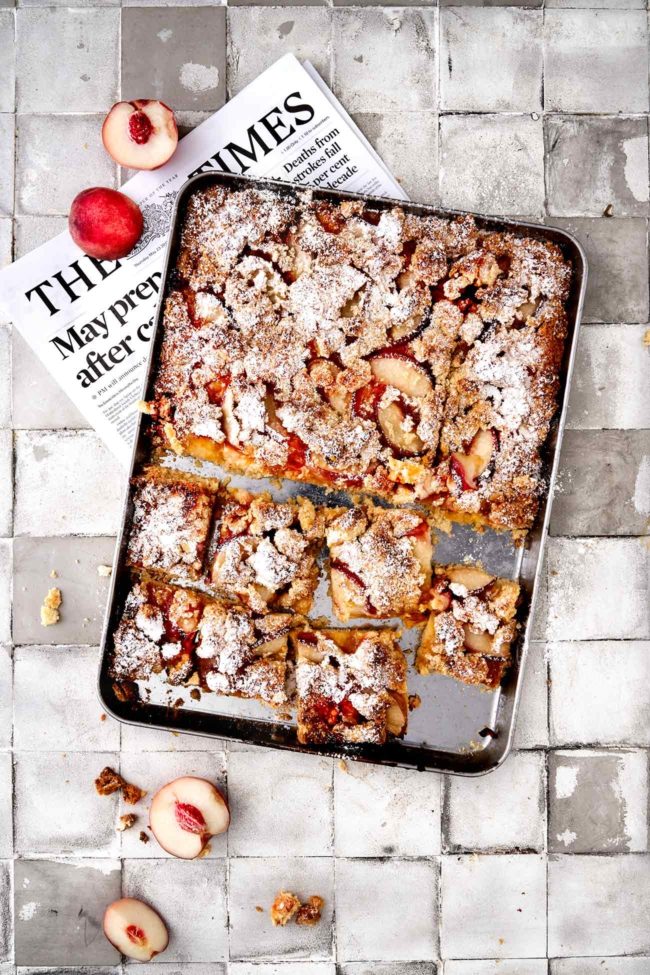 Es ist fast ein gefüllter Blechkuchen. Ich habe direkt die doppelte Menge gemacht und ihn direkt auf dem Backblech gebacken. Als Topping gibt es frische Pfirsichhälften und knusprige Mandelstreusel. Innen wartet eine klebrige Marmelade, die du nach Lust und Laune auswechseln kannst. Ich habe Passionsfrucht genommen. Herrlich