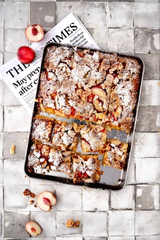 Es ist fast ein gefüllter Blechkuchen. Ich habe direkt die doppelte Menge gemacht und ihn direkt auf dem Backblech gebacken. Als Topping gibt es frische Pfirsichhälften und knusprige Mandelstreusel. Innen wartet eine klebrige Marmelade, die du nach Lust und Laune auswechseln kannst. Ich habe Passionsfrucht genommen. Herrlich