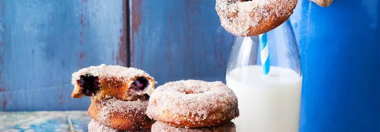 Ganz tief in meiner Backformen-Kiste habe ich sie wieder entdeckt. Die Donutform. Es wurde daher echt Zeit sich mal wieder an gebackene Donuts zu machen. Und ich könnte mir keinen besseren Donut vorstellen, der voll fruchtiger Blaubeeren ist und dann noch in eine Zucker-Zimt-Mischung getaucht wird.