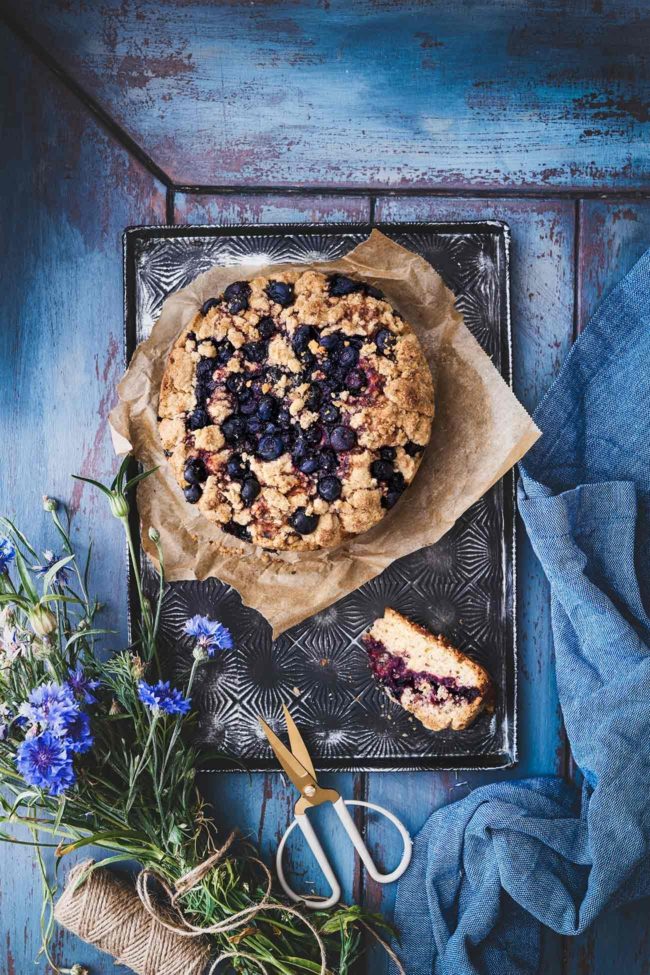 Dieser prall mit Blaubeeren gefüllte Kuchen bekommt als Krönung eine leichte Prise Kardamom. Ich liebe den Duft und den Geschmack vom frisch zerstoßenen Kardamom. Ihr könnt euch gar nicht vorstellen, mit wieviel Leidenschaft ich diesen Kuchen (gut, dass ich direkt 2 gebacken habe) verspeist habe. Gebackene Blaubeeren hinterlassen immer so eine leckere klebrig, fruchtige Masse. Dazu ein paar Streusel. Perfekt.