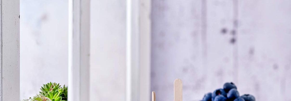 Noch nie war Joghurt machen so einfach. Mit dem Joghurtzubereiter EasiYo, den es bereits ab 29,99 Euro inkl. Joghurtpulver für 2 kg gibt, ist es richtig einfach, sich seinen Lieblingsjoghurt zuzubereiten. Das Schwierigste ist, sich zwischen den leckeren Geschmacksrichtungen zu entscheiden. Gerade im Sommer essen wir viel Joghurt. Zum Frühstück mit Obst, tagsüber gern als Frozen Joghurt und abends auch gerne als leckeres Eis am Stiel. Die Kombinationsmöglichkeiten sind unzählig. Wie das geht? Mit Wasser aufgießen, schütteln und den Rest über Nacht den Lebendkulturen überlassen. Dann nur noch kühlen und fertig ist ein köstlicher Joghurt Wir lieben besonders den Naturjoghurt nach griechischer Art ohne zusätzlichen Zuckerzusatz. Für Alle, die einen Joghurt gesucht haben, um Frozen Joghurt herzustellen, hat ihn jetzt gefunden. Denn der schmeckt wie bei den angesagtesten Frozen Joghurt Shops. Für die Popsicles habe ich mich für den Blaubeer-Joghurt entschieden. Einfach Joghurt einen Tag vorher zubereiten, in Muffinförmchen oder Kuchenförmchen füllen, Heidelbeeren darauf verteilen und ein Holzstäbchen mittig in die Form stellen und einfrieren.