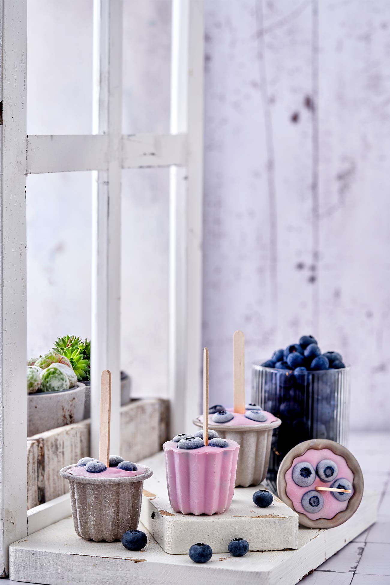 Noch nie war Joghurt machen so einfach. Mit dem Joghurtzubereiter EasiYo, den es bereits ab 29,99 Euro inkl. Joghurtpulver für 2 kg gibt, ist es richtig einfach, sich seinen Lieblingsjoghurt zuzubereiten. Das Schwierigste ist, sich zwischen den leckeren Geschmacksrichtungen zu entscheiden. Gerade im Sommer essen wir viel Joghurt. Zum Frühstück mit Obst, tagsüber gern als Frozen Joghurt und abends auch gerne als leckeres Eis am Stiel. Die Kombinationsmöglichkeiten sind unzählig. Wie das geht? Mit Wasser aufgießen, schütteln und den Rest über Nacht den Lebendkulturen überlassen. Dann nur noch kühlen und fertig ist ein köstlicher Joghurt Wir lieben besonders den Naturjoghurt nach griechischer Art ohne zusätzlichen Zuckerzusatz. Für Alle, die einen Joghurt gesucht haben, um Frozen Joghurt herzustellen, hat ihn jetzt gefunden. Denn der schmeckt wie bei den angesagtesten Frozen Joghurt Shops. Für die Popsicles habe ich mich für den Blaubeer-Joghurt entschieden. Einfach Joghurt einen Tag vorher zubereiten, in Muffinförmchen oder Kuchenförmchen füllen, Heidelbeeren darauf verteilen und ein Holzstäbchen mittig in die Form stellen und einfrieren.