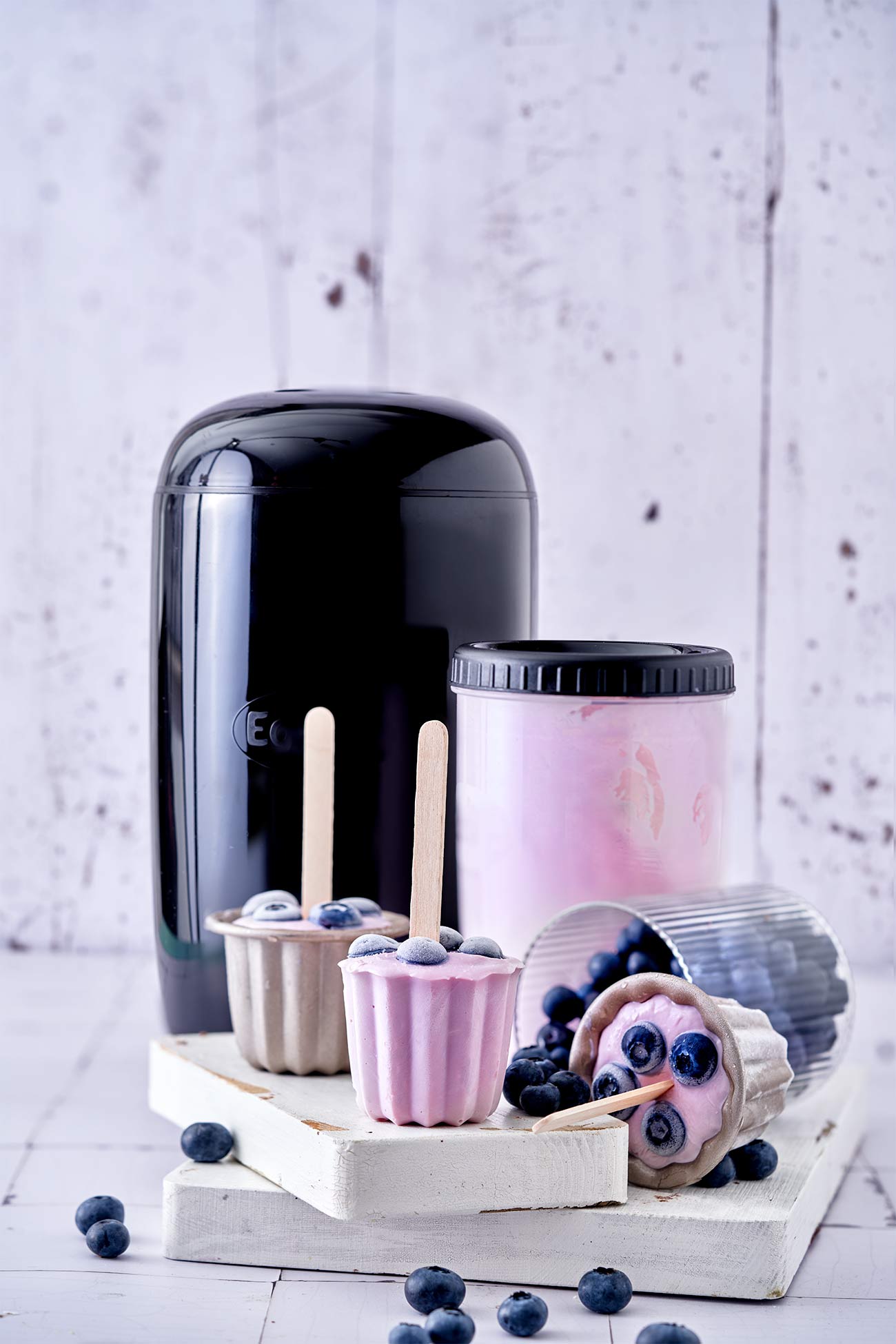 Noch nie war Joghurt machen so einfach. Mit dem Joghurtzubereiter EasiYo, den es bereits ab 29,99 Euro inkl. Joghurtpulver für 2 kg gibt, ist es richtig einfach, sich seinen Lieblingsjoghurt zuzubereiten. Das Schwierigste ist, sich zwischen den leckeren Geschmacksrichtungen zu entscheiden. Gerade im Sommer essen wir viel Joghurt. Zum Frühstück mit Obst, tagsüber gern als Frozen Joghurt und abends auch gerne als leckeres Eis am Stiel. Die Kombinationsmöglichkeiten sind unzählig. Wie das geht? Mit Wasser aufgießen, schütteln und den Rest über Nacht den Lebendkulturen überlassen. Dann nur noch kühlen und fertig ist ein köstlicher Joghurt Wir lieben besonders den Naturjoghurt nach griechischer Art ohne zusätzlichen Zuckerzusatz. Für Alle, die einen Joghurt gesucht haben, um Frozen Joghurt herzustellen, hat ihn jetzt gefunden. Denn der schmeckt wie bei den angesagtesten Frozen Joghurt Shops. Für die Popsicles habe ich mich für den Blaubeer-Joghurt entschieden. Einfach Joghurt einen Tag vorher zubereiten, in Muffinförmchen oder Kuchenförmchen füllen, Heidelbeeren darauf verteilen und ein Holzstäbchen mittig in die Form stellen und einfrieren.