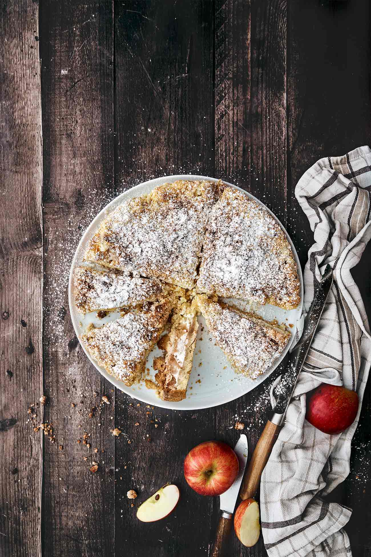 Ich freue mich so sehr auf die anstehende, regionale Apfelsaison, dass ich nicht mehr abwarten konnte und diesen saftigen Kuchen, der mit einer Skyr-Schmand Füllung überrascht, backen musste. Dazu Mandelstreusel und eine dicke Schicht aus Puderzucker. Ein Apfeltraum.   