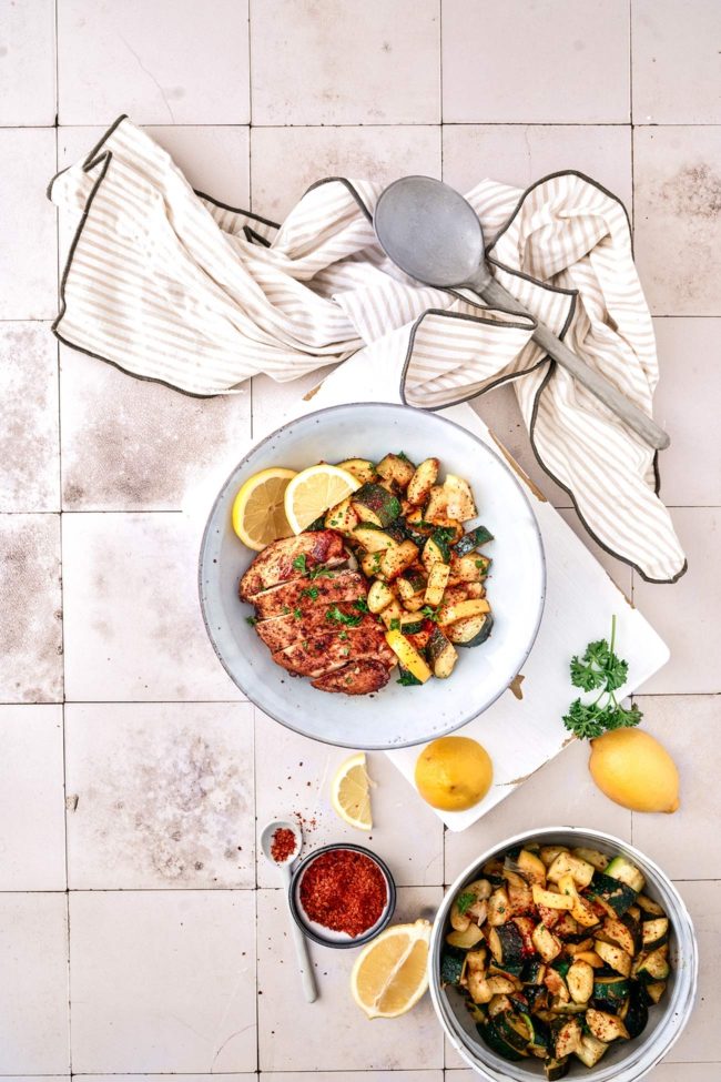 Hähnchenbrust mit sautierter Zitronen-Zucchini Für 4 Portionen 1 EL Paprikapulver 2 TL gemahlener Kümmel 60 ml Hühnerbrühe 60 ml Zitronensaft ½ TL gemahlenes Zwiebelpulver 2 TL Oregano 8 Knoblauchzehen, gehackt ½ TL Chiliflocken 60 ml Olivenöl Salz Pfeffer Sonnenblumenöl 1,2 kg Hähnchenbrust 5 Zucchini, gewürfelt 2 Bio-Zitronen, in Scheiben geschnitten und in geviertelt 1 Bio-Zitrone, in Scheiben geschnitten ½ Bund Petersilie, gehackt Paprika, Kreuzkümmel, Hühnerbrühe, Zitronensaft, Zwiebelpulver, Oregano, Knoblauch, Chiliflocken und Olivenöl in einer Schüssel vermengen und mit Salz und Pfeffer würzen. Hähnchenbrust von allen Seiten mit der Marinade bestreichen, dann ganz in die Marinade geben und mindestens 30 Minuten im Kühlschrank zugedeckt ziehen lassen. Etwas Sonnenblumenöl in einer Pfanne bei mittlerer Hitze erhitzen, die Hähnchenbrust aus der Marinade nehmen und von beiden Seiten ca. 15 Minuten braten. Hähnchenbrust auf einen Teller geben und warm halten. Zucchini in dieselbe Pfanne geben und mit Salz, Pfeffer und roten Chiliflocken würzen, bei Bedarf etwas Öl hinzufügen. Zucchini für 3 Minuten bei mittlerer Hitze sautieren, dann etwas Marinade und die Zitronenviertel zugeben. Unter Rühren 3-4 Minuten köcheln lassen. Zucchini mit in Scheiben geschnittener Hähnchenbrust auf Teller verteilen und mit der gehackten Petersilie und Zitronenscheiben servieren.
