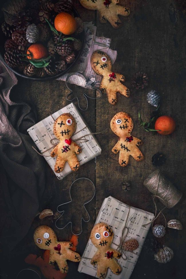Halloween steht vor der Tür - Halloween Doll Pies So langsam geht es los… Halloween steht vor der Türe. Auch wenn ich mich nicht in einen Skelett- Morphsuit zwänge (das wollt ihr auch gar nicht sehen) oder als aufgespießter Kürbis durch die Gegend laufe, darf der Kuchen etwas gruseliger werden. Und alle die mein „Halloween“ Koch- und Backbuch kennen, wissen dass man ganz schnell leckeren, kleinen Kuchen einen Halloween-Style verpassen kann. Rezept für die Mürbeteig-Pies auf dem Blog. #patrickrosenthal #handpies #halloween #halloweendolls #food #foodphotography #pies #voodoo #hautescuisines #lebkuchenmann #gruselig #halloweenparty #voodoodolls – inspired by #notquitenigella @notquitenigella 6-8 Stück 3 Rollen frischer Mürbeteig 1 Ei ½ Glas Himbeermarmelade 1 Tube schwarze Zuckerschrift Rote Lebensmittelfarbe Weißer Fondant Ausstechform Lebkuchenmann Backofen auf 200 Grad Ober-Unterhitze vorheizen und 2 Backbleche mit Backpapier auslegen. Mürbeteig entrollen. Mit dem Ausstecher 12-16 (je nach Größe deines Ausstechers) Lebkuchenmännchen ausstechen und die Hälfte davon auf die Backbleche verteilen. Ei mit 1 El Wasser verquirlen und die Ränder der Teigmännchen einpinseln. Je 1 kleinen Teelöffel Marmelade auf den Kopf und Bauch der Teigmännchen verteilen. Je einen zweiten ausgestochenen Teig auf die Männchen setzen und die Ränder mit einer Gabel zusammendrücken. Männchen mit dem Eiermischung einpinseln. Mit einem scharfen Messer ein Kreuz in den Bauch ritzen. Im Ofen 20-25 Minuten goldbraun backen, herausnehmen und vollständig auskühlen lassen. Halloween Dolls nach Lust und Laune verzieren. TIPP: Ich habe für die Herzen aus fertigem ausgerolltem Fondant kleine Herzen ausgeschnitten und diese mit roter Lebensmittelfarbe bepinselt. Die Augen habe ich ebenso mit einem kleinen runden Keksausstecher (oder Strohhalm) ausgestochen. Inspiriert wurde ich durch die Voodoo Halloween Pies von Lorraine Elliott.