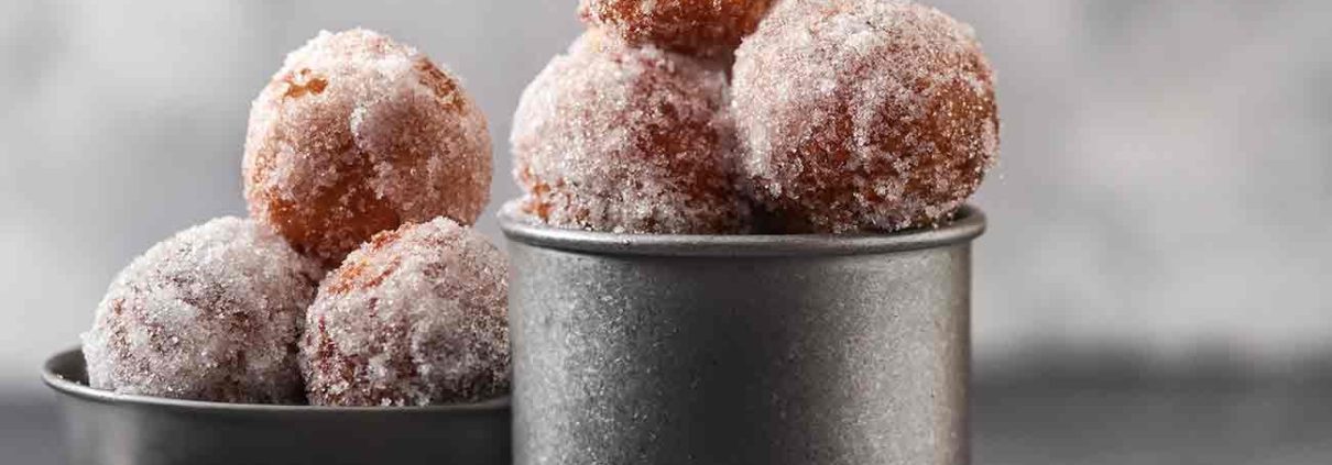 Was für ein schöner Name, oder? Eigentlich verbirgt sich dahinter auch „nur“ frittierte kleine Krapfen, die nach dem Frittieren noch mit Pudding, Nutella oder Marmelade gefüllt werden. Meine Oma, die ich leider nie kennengelernt habe, stammte aus Italien und hat darauf bestanden, dass es Bigniole di Carnevale zur Faschingszeit gibt. Und eben keine Krapfen. In den meisten Regionen Italiens werden sie aus Brandteig hergestellt und sind wie kleine Windbeutel. Meine Oma hat jedoch immer behauptet, dass man sie in Sizilien genau so nach ihrem Rezept macht. Na dann. Meine Mama hat dann diese kleinen frittierten Teigkugeln immer zu Karneval gebacken. Bei mir bekommen die Kleinen noch einen lustigen Cowboyhut aufgesetzt. Wie lustig!