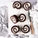 Schoko-Bananen-Rolle Chocolate Banana Roll Ich könnte jeden Tag eine Biskuitrolle machen. Sie ist so schnell gemacht und einfach unglaublich vielfältig. Ich mag sie am liebsten, wenn der Teig ganz dünn ist und ganz viel Creme eingerollt wurde. Fluffiger Schokoteig und innen einen süße Bananen-Mascarponecreme. 5 Eier 1 Prise Salz 160 g Zucker 100 g Mehl 30 g Backkakao 30 g Speisestärke 1 EL Backpulver Bananencreme 400 ml Bananensaft 80 g Zucker 40 g Speisestärke 200 g Mascarpone Für die Füllung Bananensaft und Zucker aufkochen lassen. 4 EL davon abnehmen und mit der Speisestärke verrühren. Stärke in den Topf gießen und unter Rühren kurz aufkochen lassen, danach vollständig auskühlen lassen. Mascarpone unterrühren und bis zur Verwendung zur Seite stellen. Backofen auf 180 Grad Ober-Unterhitze vorheizen und ein Backblech mit Backpapier auslegen. Eier trennen und Eiweiße mit dem Salz steif schlagen. Zum Ende hin 110 g Zucker einrieseln lassen und weiterschlagen bis sich der Zucker vollständig aufgelöst hat. Eigelbe unterrühren. Mehl, Stärke, Backkakao und Backpulver vermengen und unter die Eiermasse heben. unterheben Teig auf das Backpapier verstreichen und im Ofen 15 Minuten backen Ein Küchenhandtuch (ich mache es immer leicht feucht) ausbreiten und mit restlichem Zucker bestreuen. Biskuit aus dem Ofen nehmen und sofort auf das Küchenhandtuch stürzen und mithilfe des Küchentuchs, von der langen Seite her aufrollen und auskühlen lassen. Biskuit vorsichtig entrollen, Creme darauf verteilen und (ohne Küchenhandtuch) wieder aufrollen. Mindestens 2 Stunden kaltstellen.