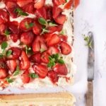 Der Blechkuchen mit gerösteten Erdbeeren lässt mir noch beim Schreiben das Wasser im Mund zusammenlaufen. Wenn du die Erdbeeren mit Honig und Thymian röstest, entsteht ein köstlicher Erdbeersirup, der den Kuchen perfekt ergänzt. Dieser Blechkuchen besteht aus drei unwiderstehlichen Schichten, die jeden Bissen zu einem Genuss machen. Die erste Schicht ist der Boden, mit leichtem Orangengeschmack.Dieser Boden bildet die perfekte Grundlage für den Kuchen und bietet einen angenehmen Kontrast zu den cremigen Toppings. Die zweite Schicht ist die verlockende Käsekuchenfüllung mit Frischkäse und cremigen Ricotta, die im Ofen gebacken wird. Die dritte Schicht ist eine Creme aus Mascarpone und frischer Sahne und den gerösteten Honig-Erdbeeren. Der Honig karamellisiert leicht und verleiht den Erdbeeren eine süße Note, während der Thymian einen subtilen Hauch von Kräutern hinzufügt. Verteile die gerösteten Erdbeeren auf dem gebackenen Käsekuchen und beträufle ohn mit dem entstandenen Erdbeersirup.