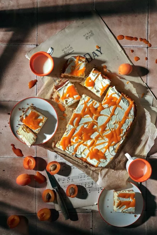 Tadaaaa…..! Vorhang auf für den König der Kuchen – den Cheesecake. Aber halt! Heute präsentiere ich dir eine Variante, die nicht nur deinen Käsekuchen-Gelüsten gerecht wird, sondern auch deine Obst-Liebe erfüllt. Stell dir eine cremige, üppige Cheesecake-Schicht vor, die auf einem knusprigen Keksboden liegt. Doch das ist nicht alles – die wahre Krönung ist eine Schicht aus dem Crème Fraîche-Topping, mit einem süß-sauren Aprikosenpüree.
