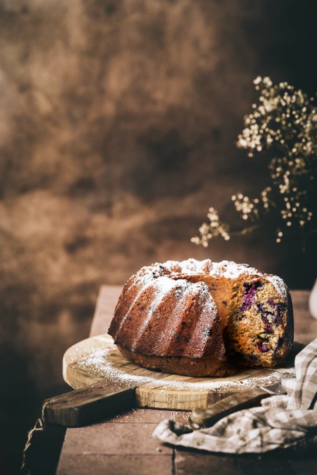 Aufgeschnittener Gugelhupf aus Karotten und Blaubeeren, rustikal angerichtet